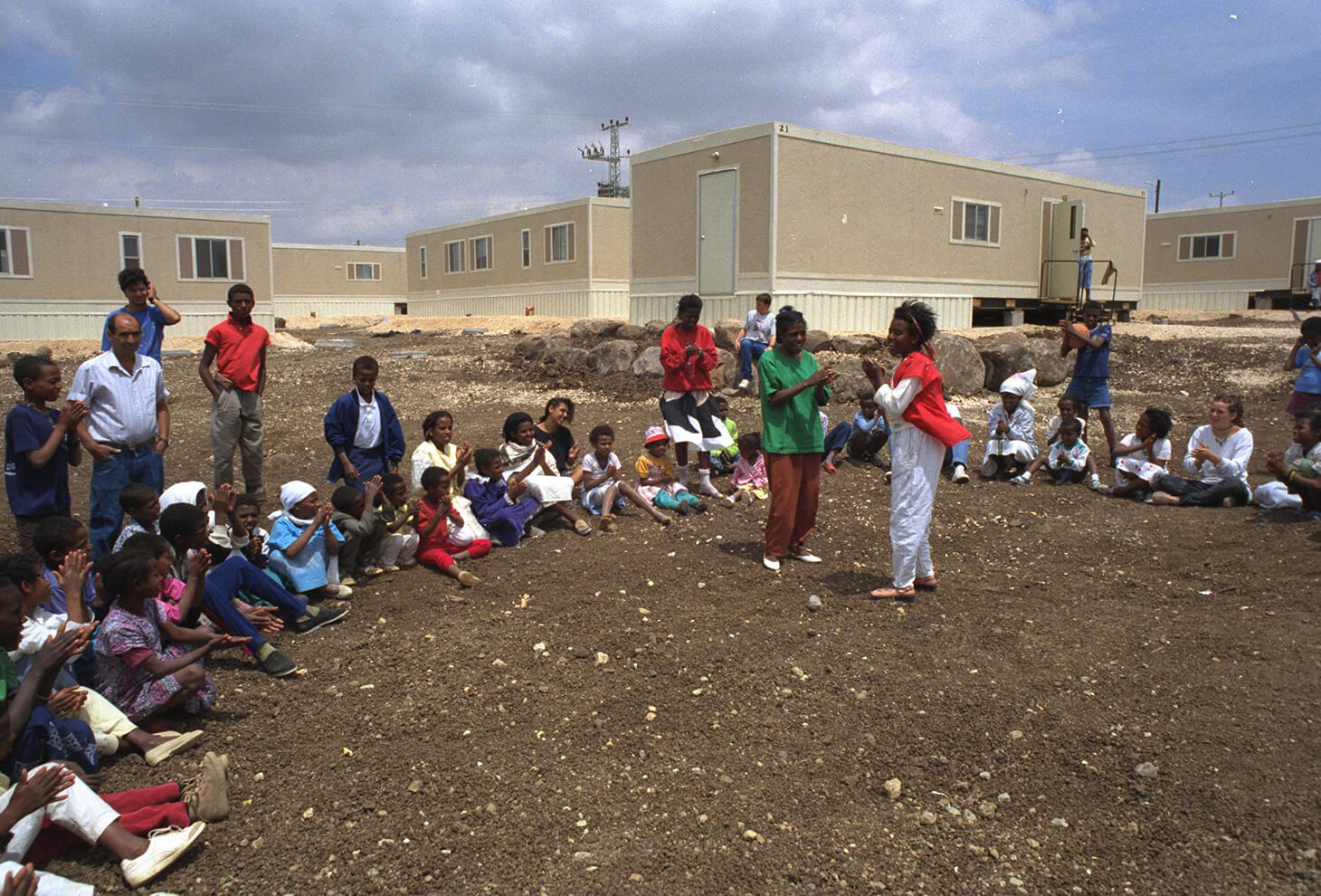 SINGING AND DANCING AT KFAR TABOR MOBILE HOMESITE,WITH CHILDREN FROM NEARBY MOSHAVIM, OPERATION SOLOMON, ETHIOPIAN IMMIGRANTS. Photo: Doron Horowitz, GPO